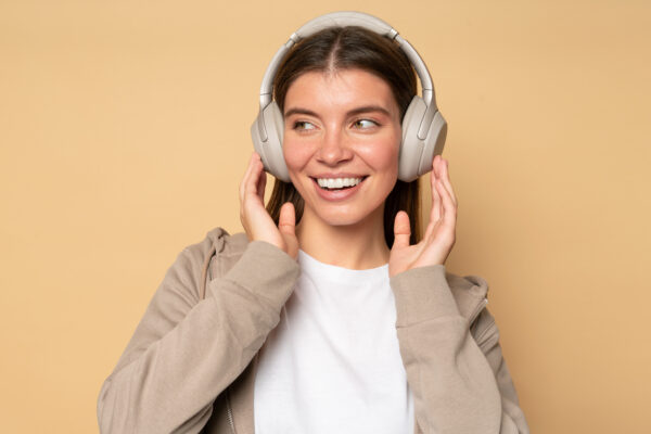 Portrait of millennial girl listening to podcast on favorite radio station in wireless headphones